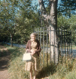 Mrs Caroline Rosson, at fenced tree on Memorial Avenue (Shelbourne Street near San Juan), ca. 1960