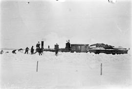 Digging train engine out from snow near Melita, Manitoba